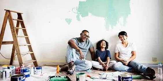 Black family painting house wall