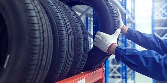 Large modern warehouse with forklifts and stack of car tires