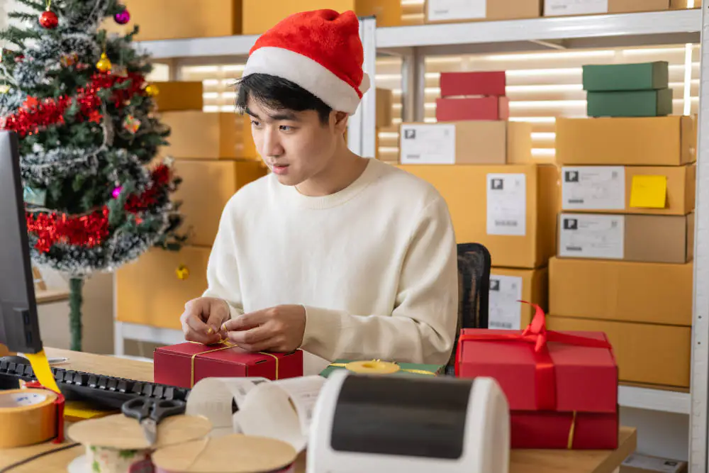 Bild mit einer Person, die zu Weihnachten Pakete einpackt.